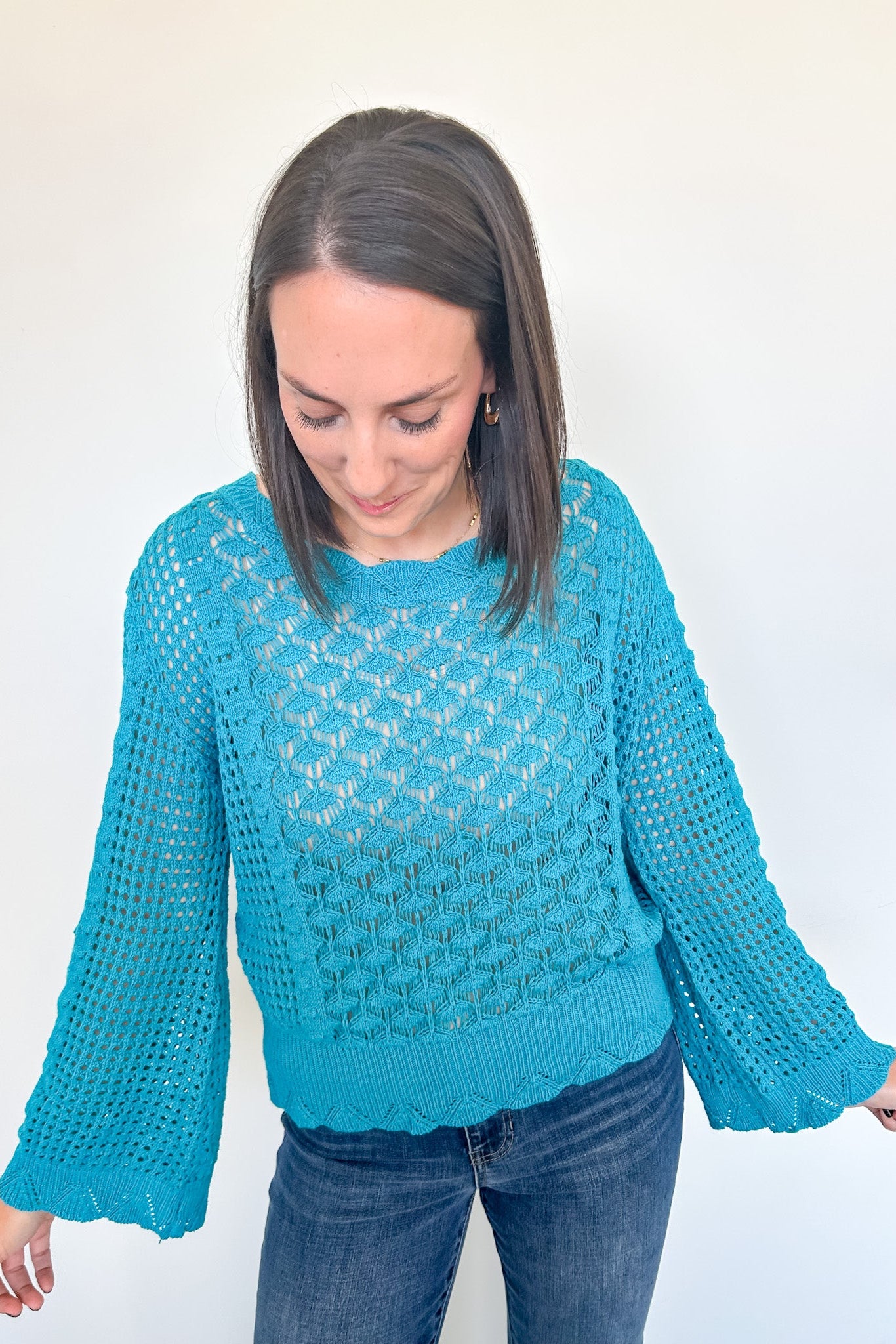 Woman wearing a blue knitted sweater against a white background