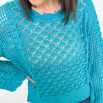Person wearing a blue knitted sweater against a white background