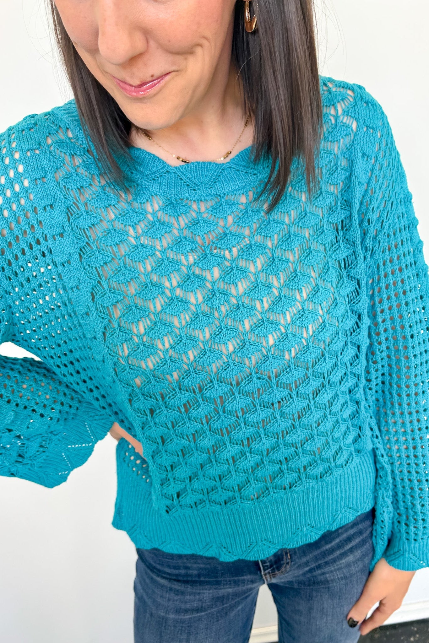 Person wearing a blue knitted sweater against a white background
