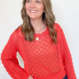 Woman wearing a red sweater against a white background