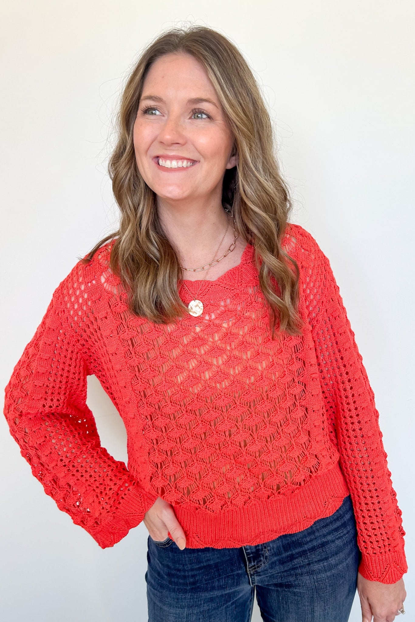 Woman wearing a red sweater against a white background