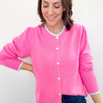 Woman wearing a pink cardigan against a white background