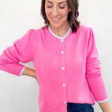 Woman wearing a pink cardigan against a white background