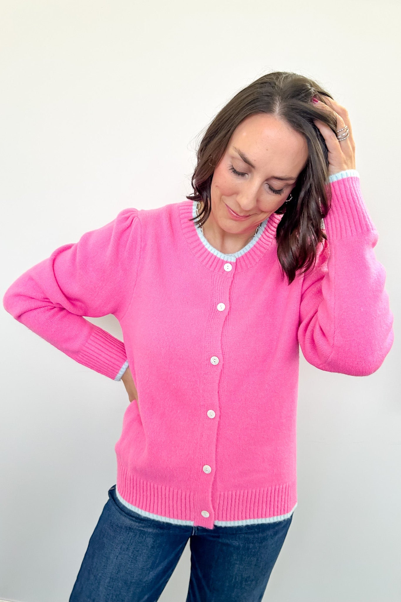 Woman wearing a pink cardigan against a white background