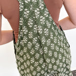 Green floral dress with a criss-cross back worn by a person on a white background