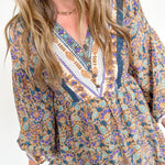 Woman wearing a patterned dress with long sleeves on a white background