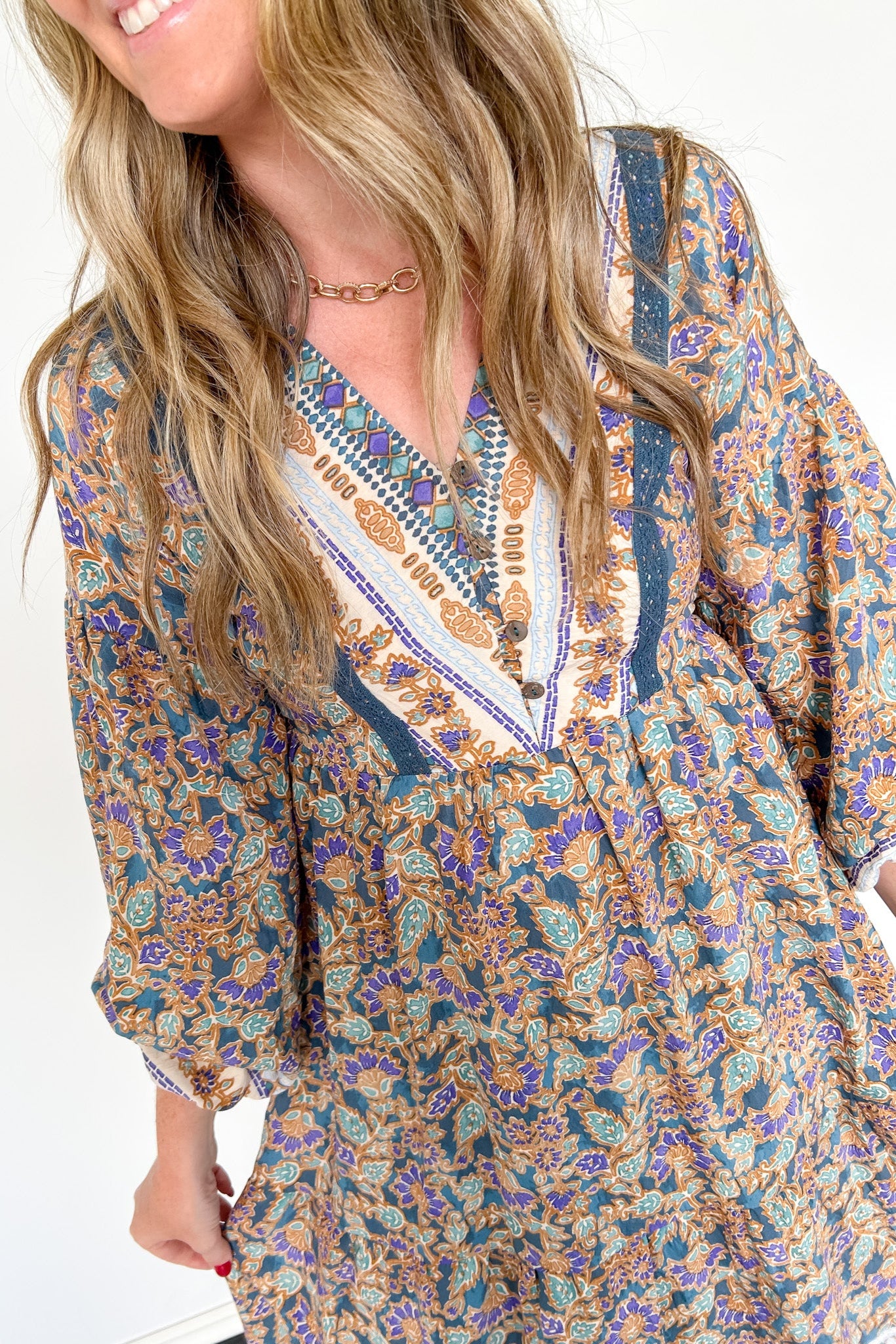 Woman wearing a patterned dress with long sleeves on a white background