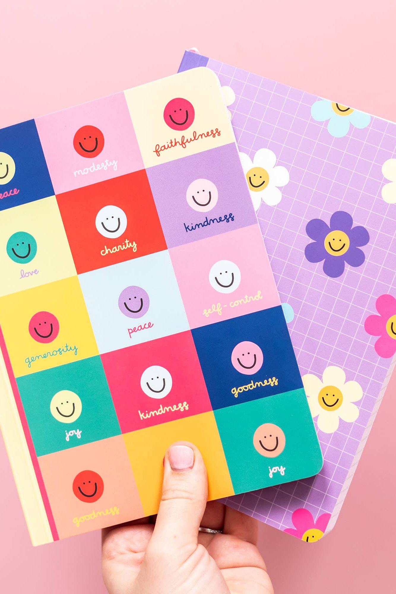 Colorful sticker sheets with smiley faces and motivational phrases on a pink background