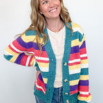 Woman wearing a colorful striped cardigan against a white background