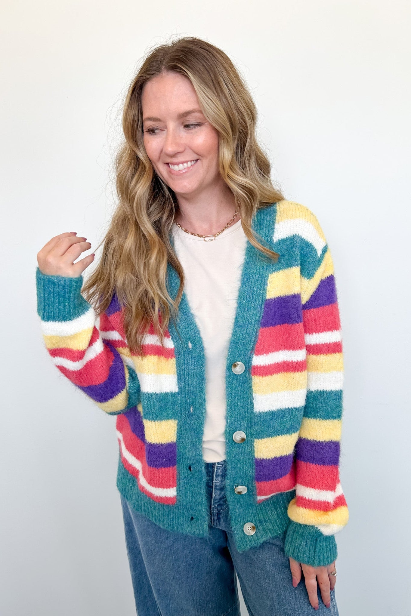 Woman wearing a colorful striped cardigan on a white background