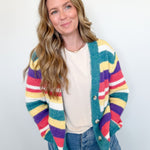 Woman wearing a colorful striped cardigan against a white background
