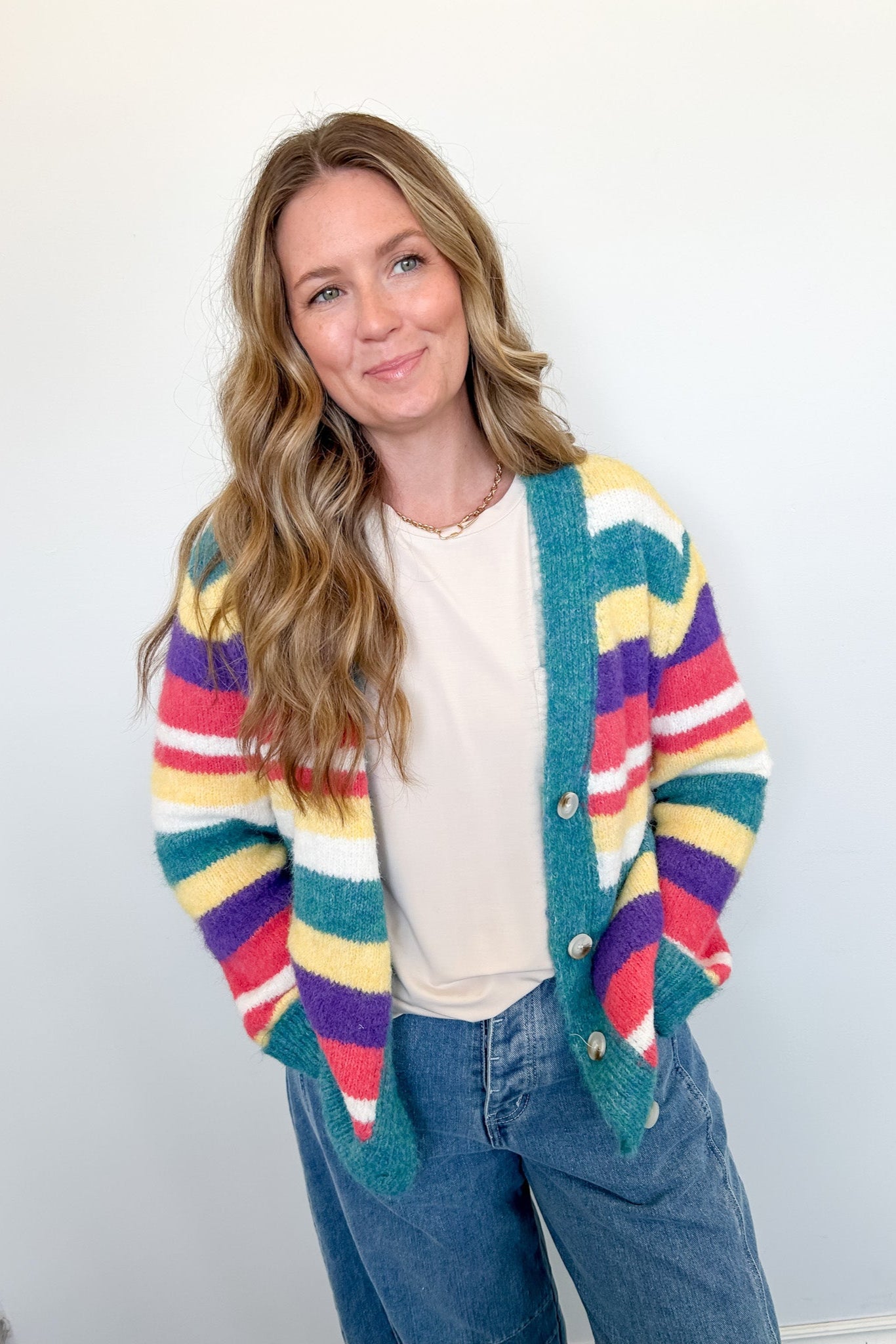 Woman wearing a colorful striped cardigan against a white background