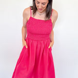 Woman wearing a bright pink dress against a white background