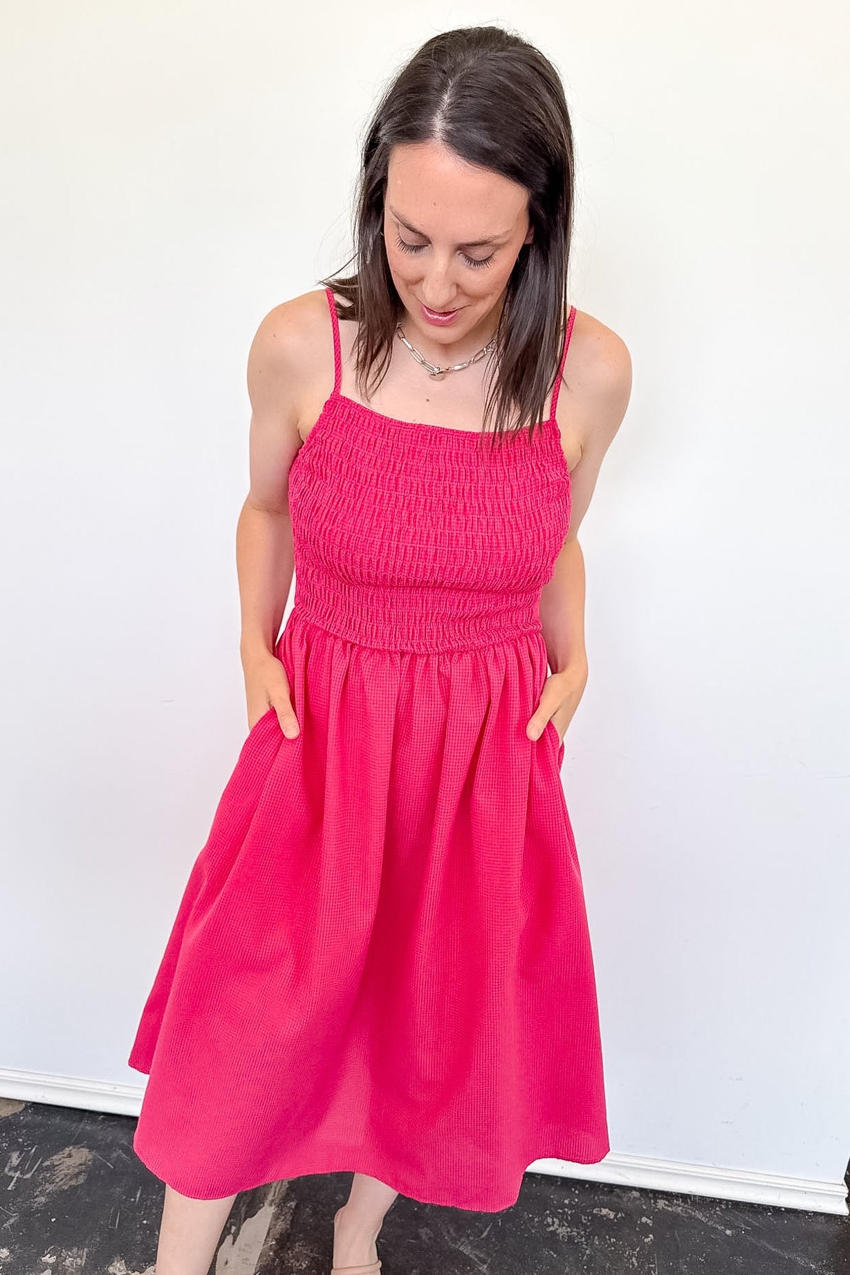 Woman wearing a bright pink dress against a white background