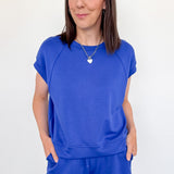 Woman wearing a blue outfit against a white background