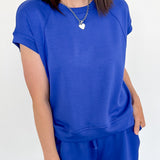 Person wearing a blue outfit with a white wall background