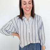 Woman wearing a striped shirt and jeans against a white background