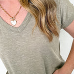 Person wearing a green t-shirt and floral pants with a plain background
