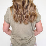 Person wearing a green t-shirt and floral pants against a white background