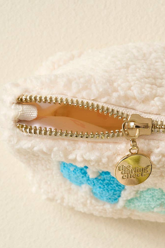 Close-up of a gold zipper on a textured surface with a brand tag.