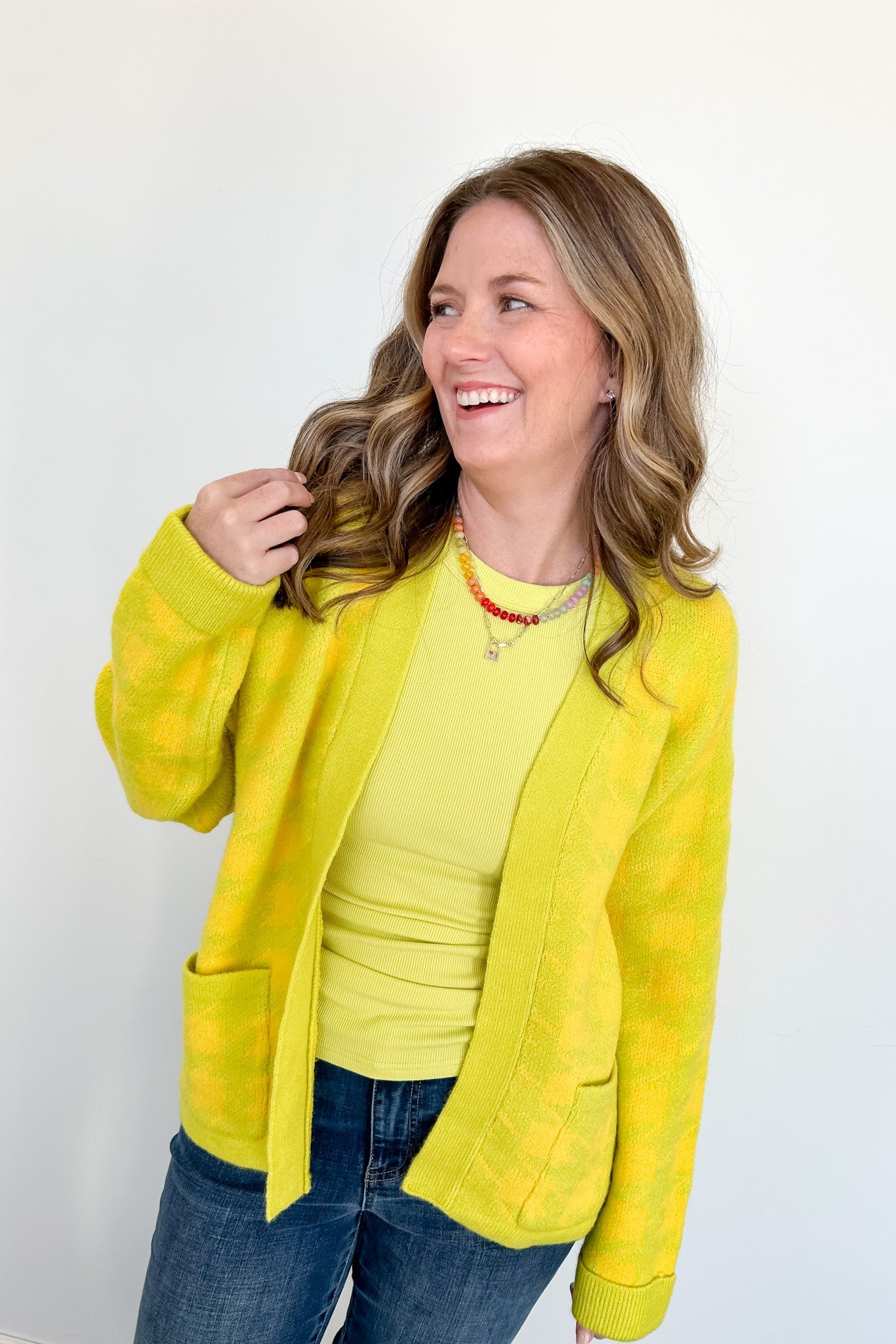 Woman wearing a yellow jacket and shirt against a white background