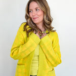 Woman wearing a bright yellow jacket against a white background