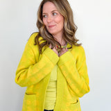 Woman wearing a bright yellow jacket against a white background