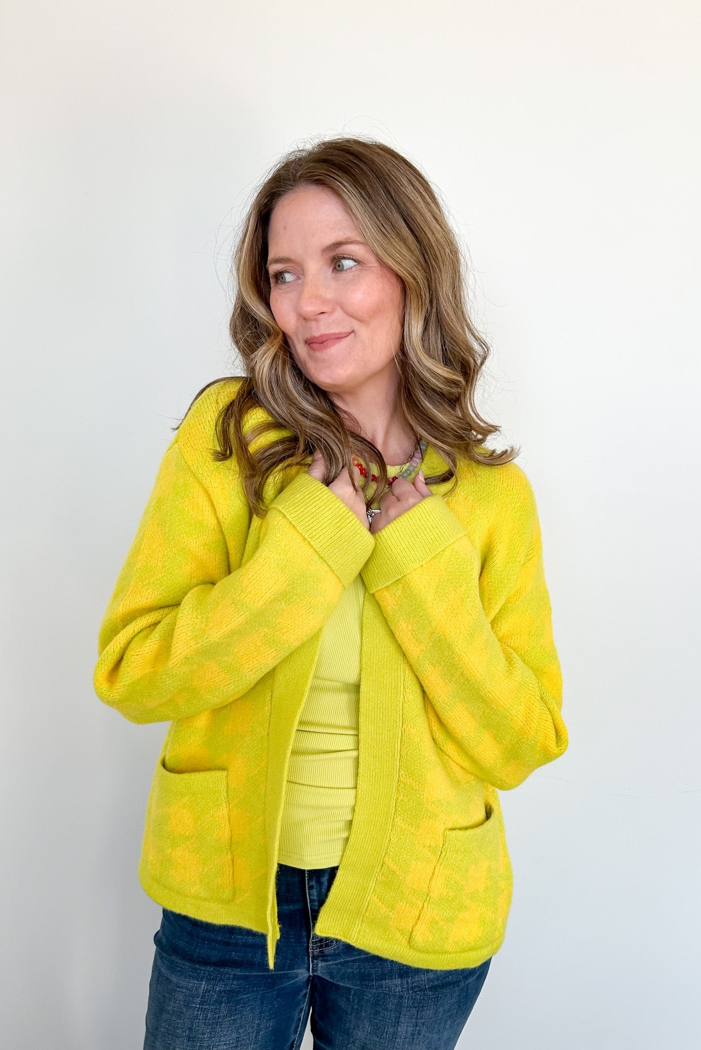 Woman wearing a bright yellow jacket against a white background