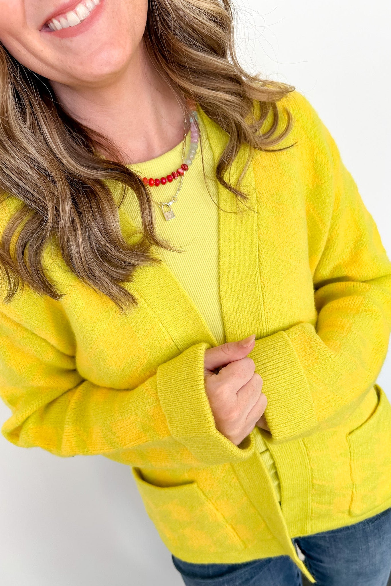 Person wearing a bright yellow sweater against a white background
