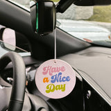 Car air freshener with 'Have a Nice Day' message hanging from a car's rearview mirror.