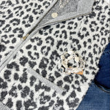 Leopard print vest with gray collar and trim, paired with jeans and a necklace.