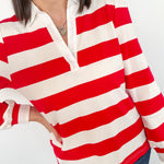 Person wearing a red and white striped shirt with a blurred background