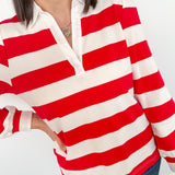 Person wearing a red and white striped shirt with a blurred background