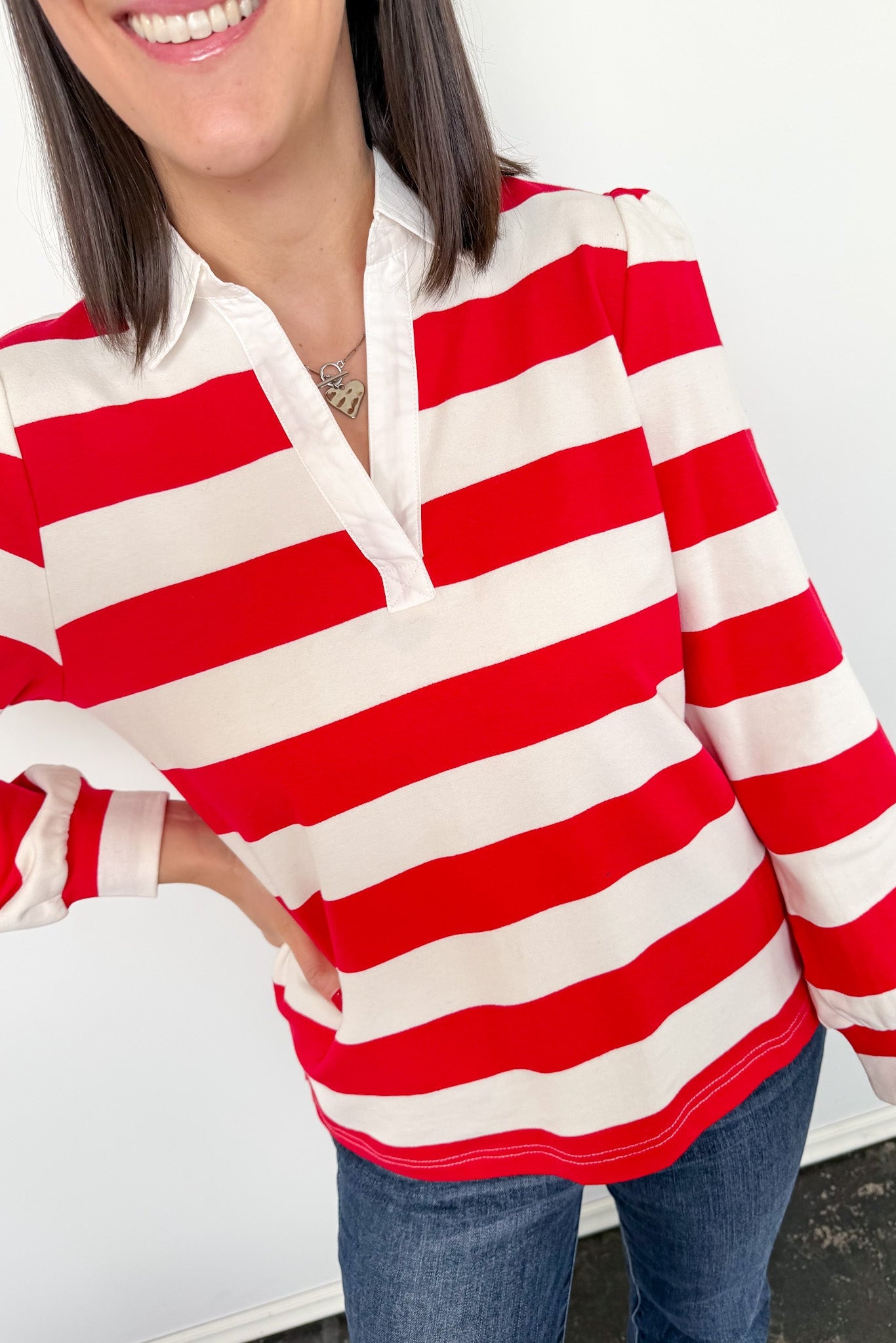 Person wearing a red and white striped shirt with a blurred background