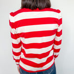 Person wearing a red and white striped sweater against a plain background