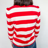 Person wearing a red and white striped sweater against a plain background