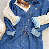 Blue denim dress with beige sleeves on a neutral background