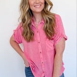 Woman wearing a pink shirt and blue jeans against a white background