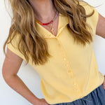 Woman wearing a yellow blouse and blue jeans against a white background