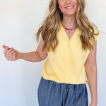 Woman wearing a yellow top and blue jeans against a white background