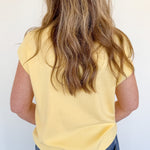 Person wearing a yellow shirt and blue jeans against a white background