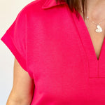 Athleisure dress that hits above the knees. Collared and short sleeve. Features a v neckline and pockets.  Fuchsia in color.