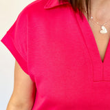 Athleisure dress that hits above the knees. Collared and short sleeve. Features a v neckline and pockets.  Fuchsia in color.