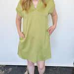 Athleisure dress that hits above the knees. Collared and short sleeve. Features a v neckline and pockets.  Kiwi in color.