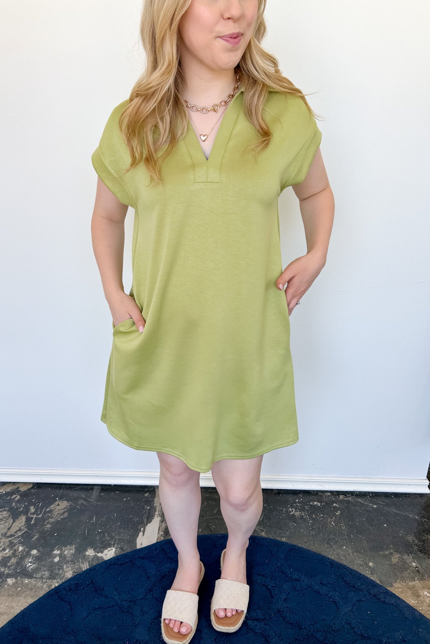 Athleisure dress that hits above the knees. Collared and short sleeve. Features a v neckline and pockets.  Kiwi in color.