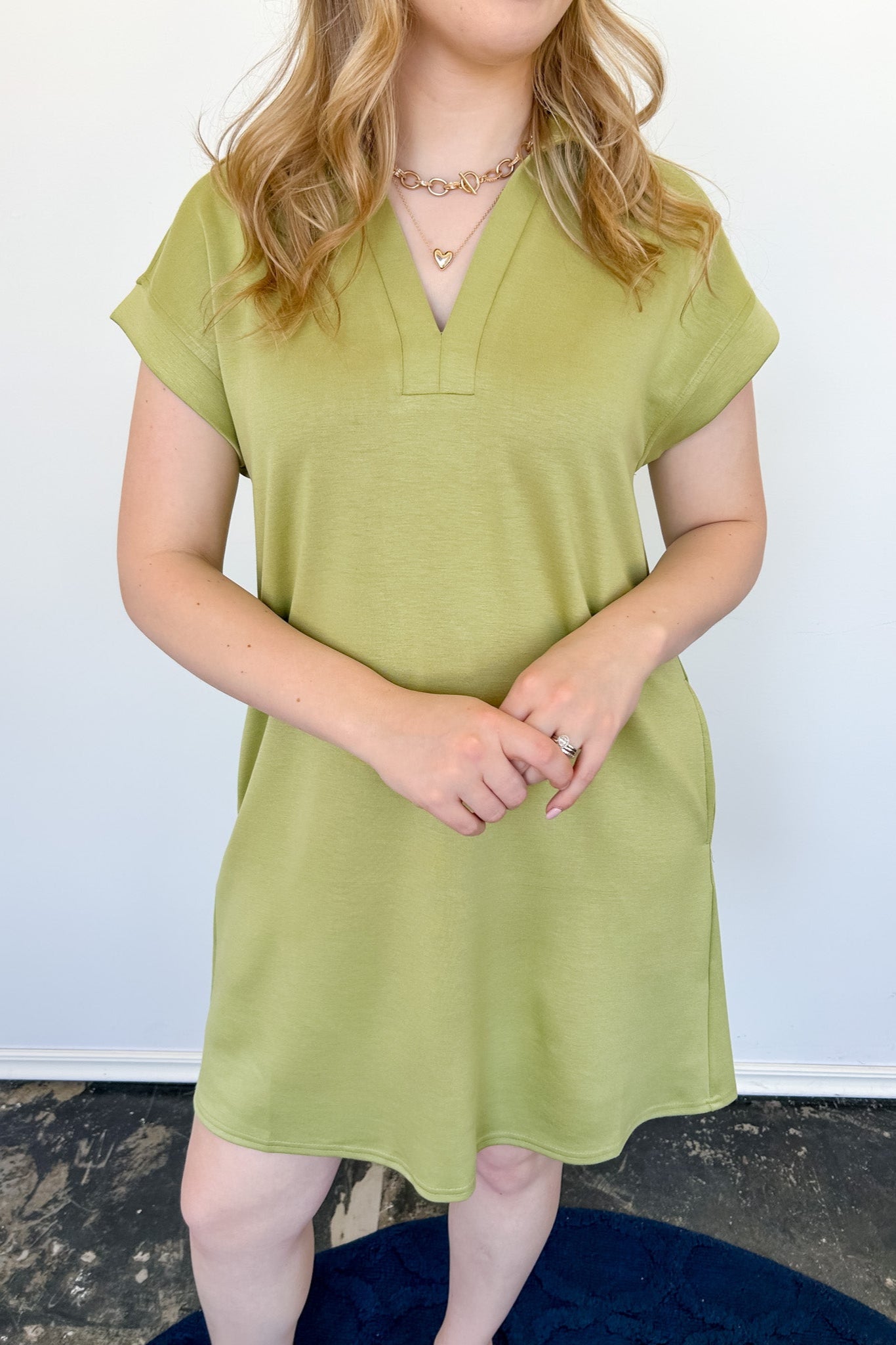 Athleisure dress that hits above the knees. Collared and short sleeve. Features a v neckline and pockets.  Kiwi in color.