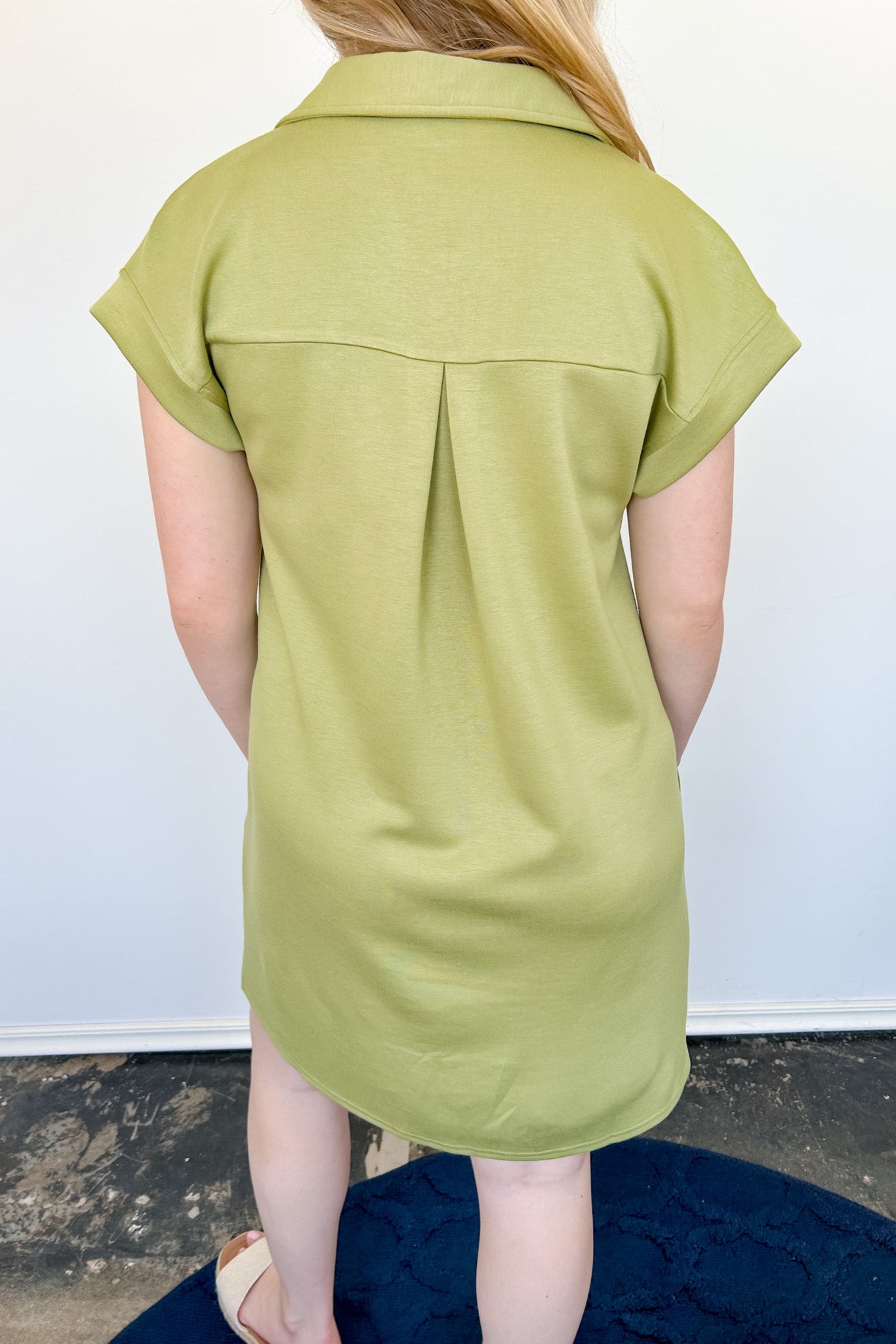 Athleisure dress that hits above the knees. Collared and short sleeve. Features a v neckline and pockets.  Kiwi in color.
