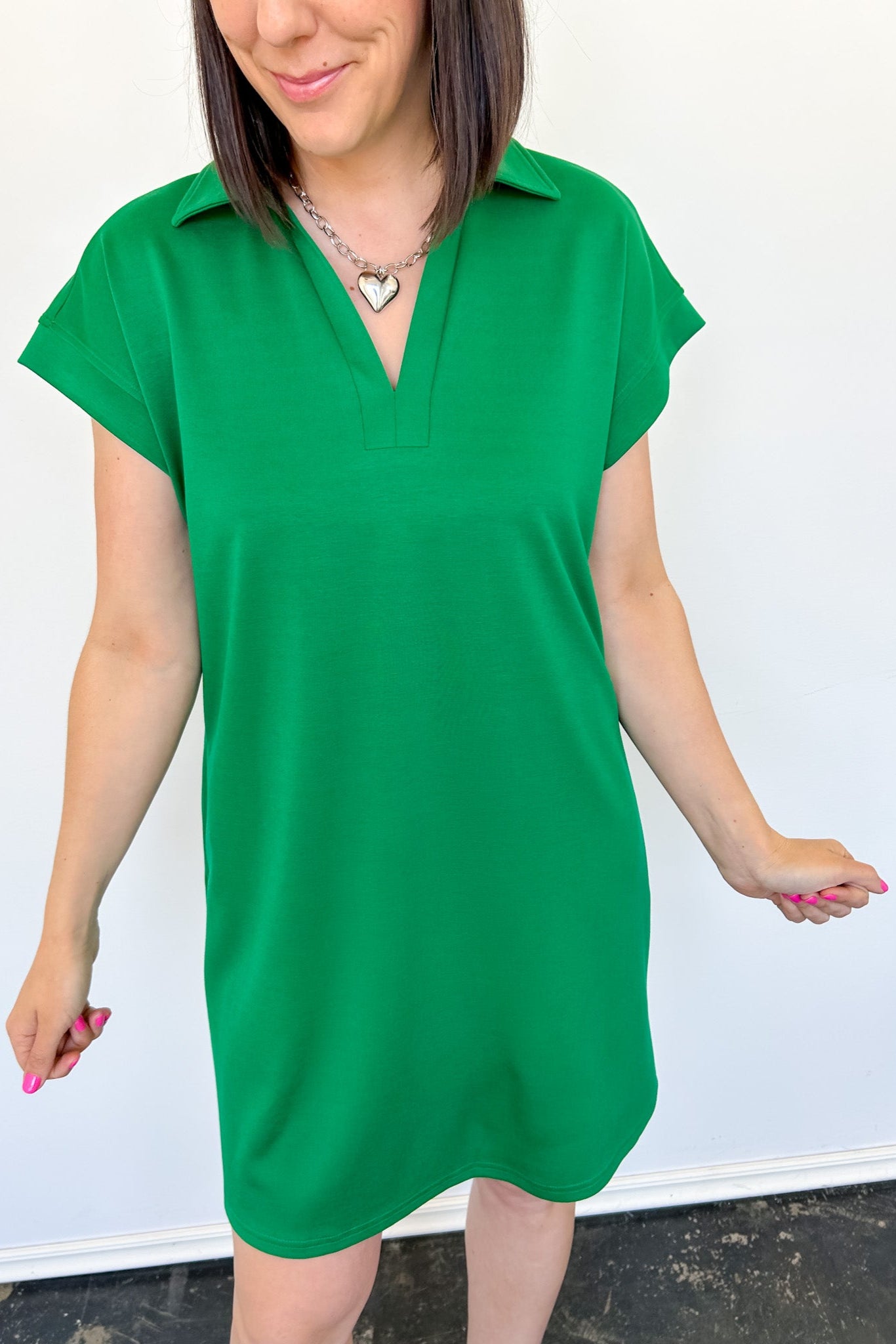 Athleisure dress that hits above the knees. Collared and short sleeve. Features a v neckline and pockets.  Emerald in color.