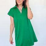 Athleisure dress that hits above the knees. Collared and short sleeve. Features a v neckline and pockets.  Emerald in color.