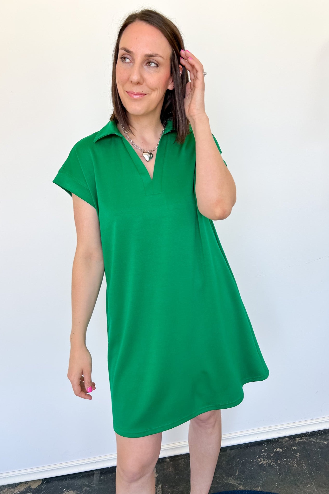 Athleisure dress that hits above the knees. Collared and short sleeve. Features a v neckline and pockets.  Emerald in color.